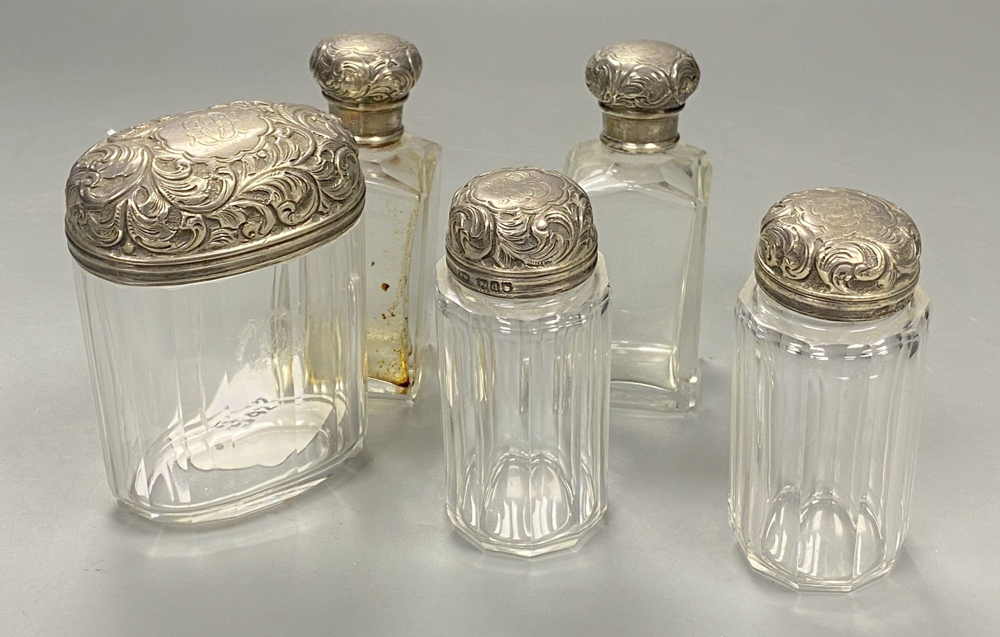 Five silver lidded powder bottles